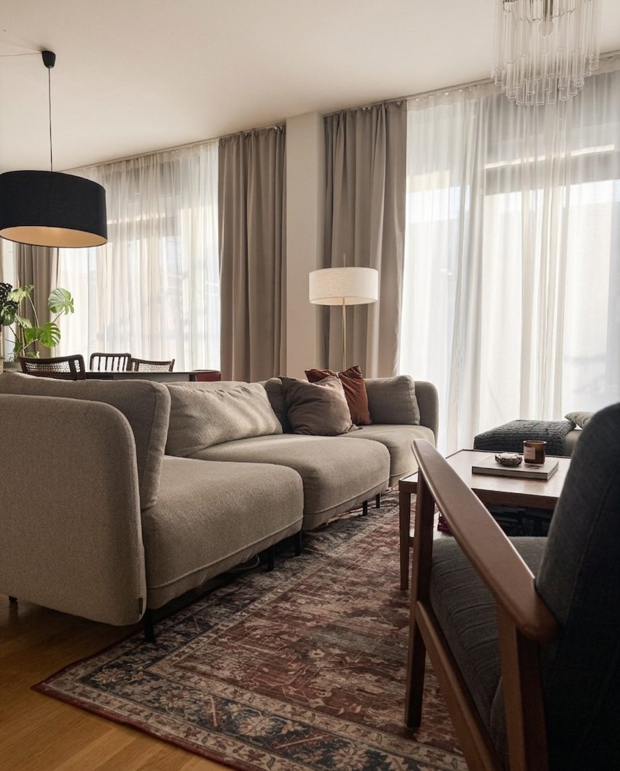 Wohnzimmer mit grauem Sofa, Orientteppich und warmem Licht — Interior Design von Ulli Zelle