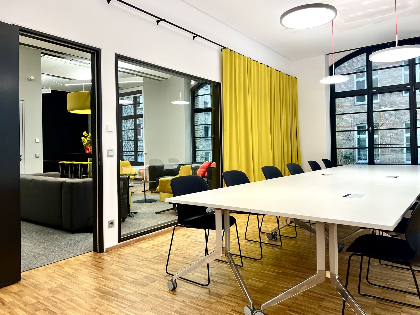 Meetingraum mit Glaswand und Blick in den offenen Bereich